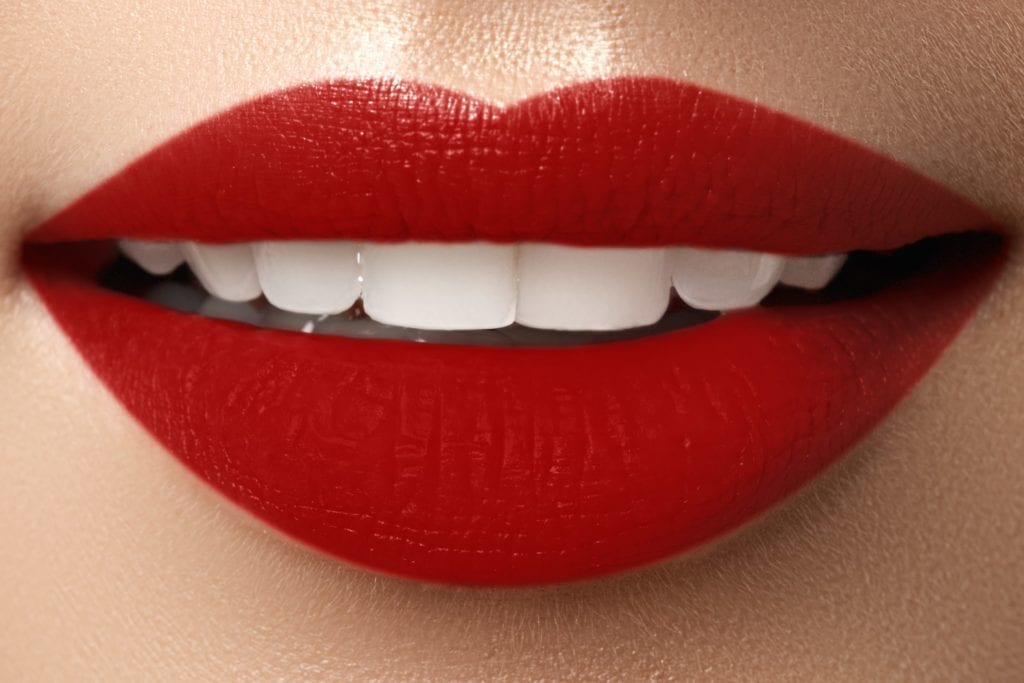 close up of red lips and white teeth