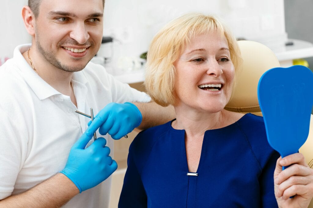 woman looking in a mirror at dentist's office