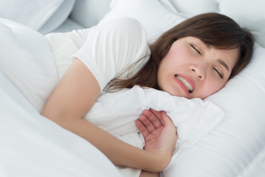 woman grinding her teeth in bed