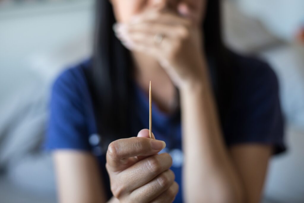 woman holding a toothpick