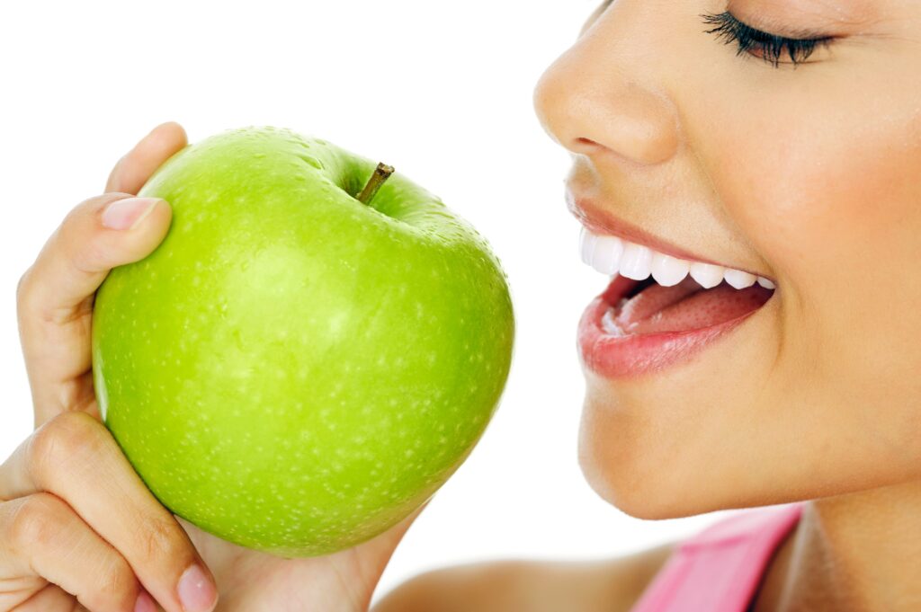 woman with straight teeth biting into an apple